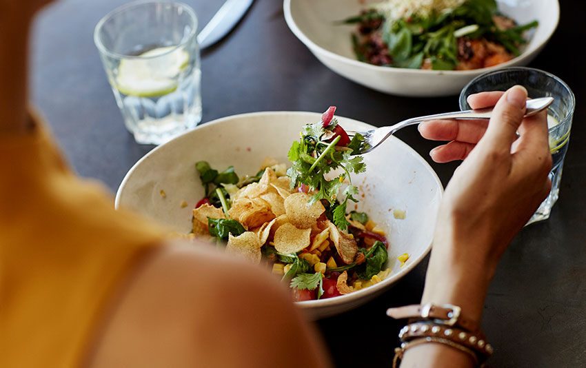 a person eating a healthy salad at a restaurant